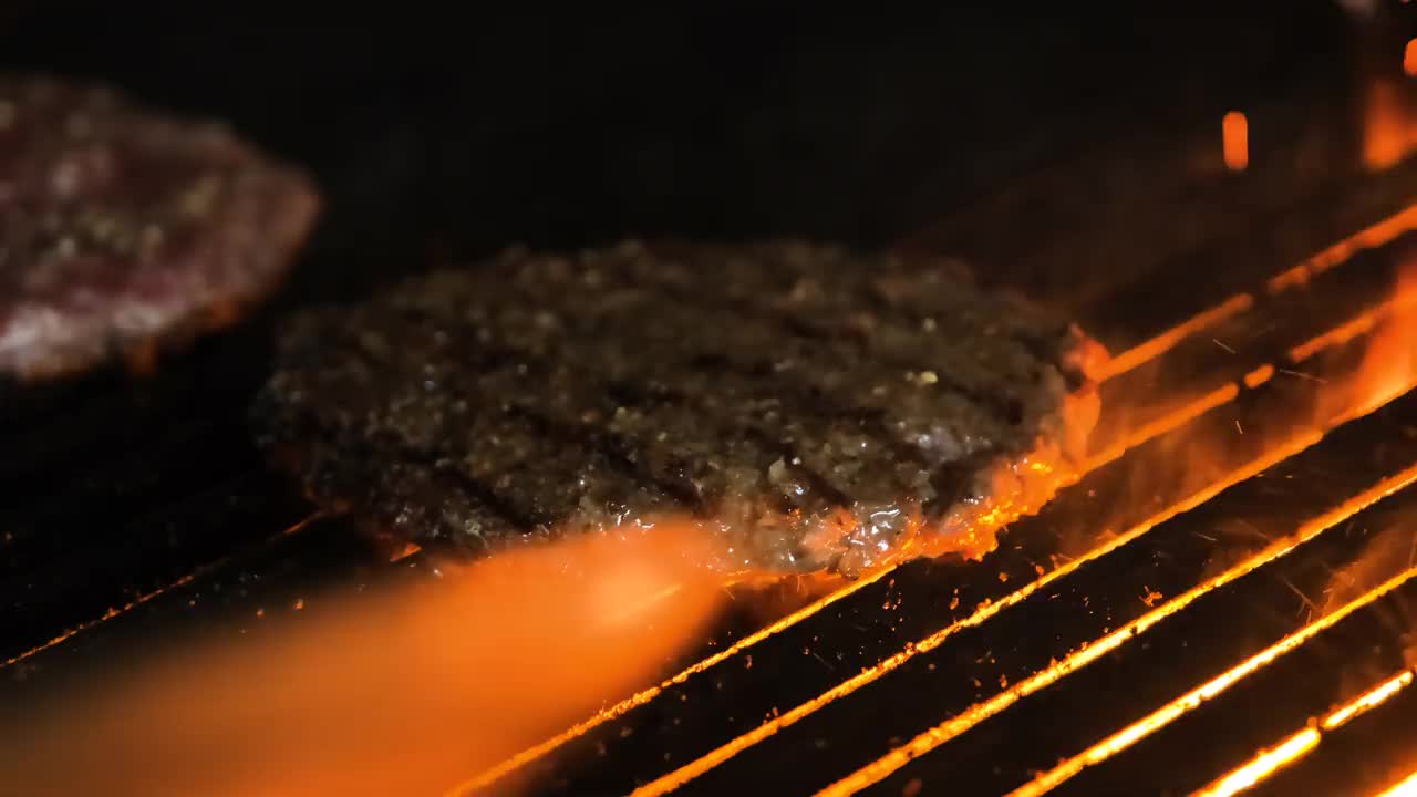 烤肉架上用来做汉堡的美味肉。火是燃烧。视频素材