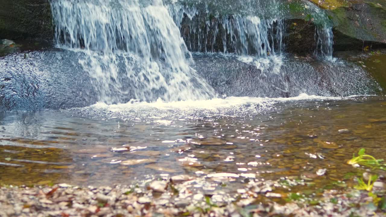 秋天在岩石间有快速流动的清澈水流的小山涧。视频素材