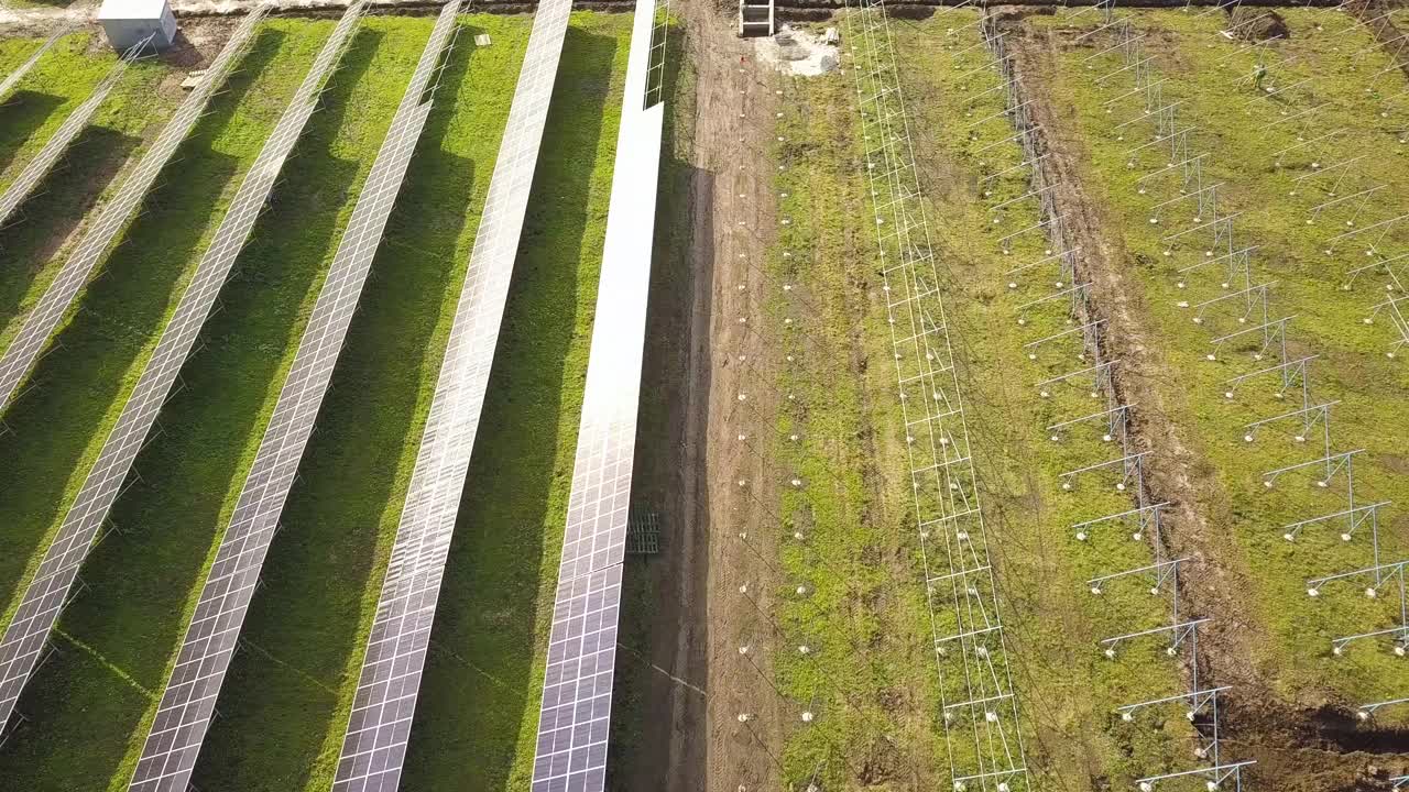 绿地上正在建设的太阳能发电厂鸟瞰图。生产清洁生态能源的电板组装。视频素材