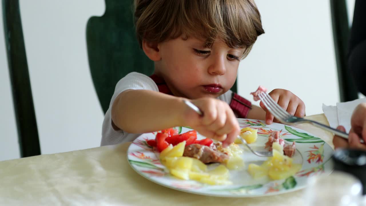 孩子吃东西，妈妈喂蹒跚学步的孩子吃午饭视频素材