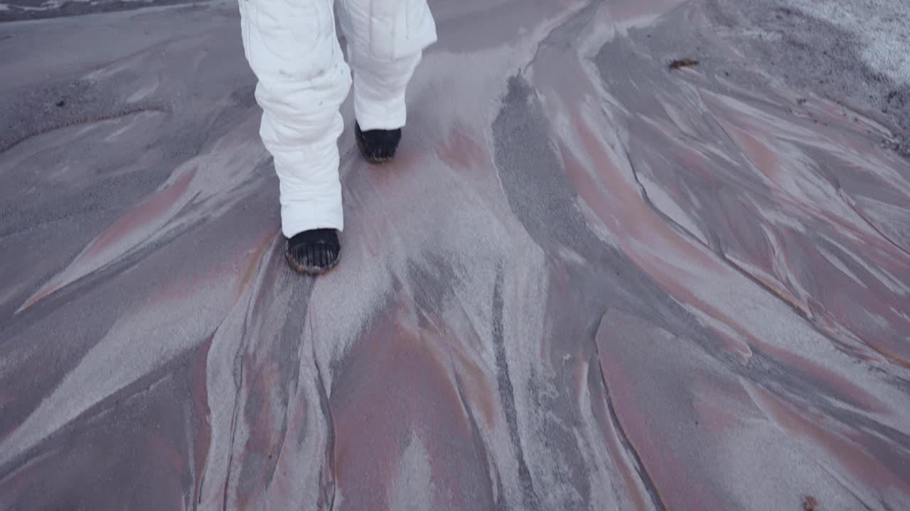 宇航员在一颗未知行星的固体表面上缓慢而小心地行走视频素材