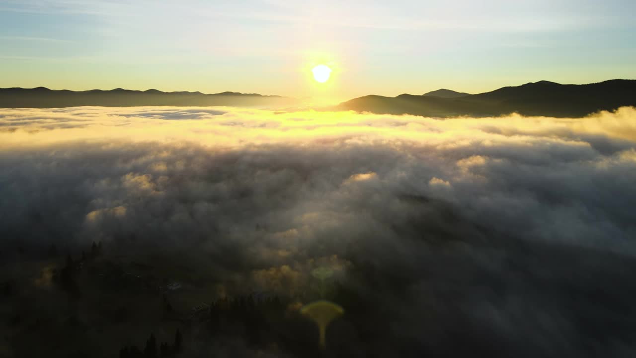 鸟瞰图的小村庄的房子在山顶在秋天雾山日出。视频素材