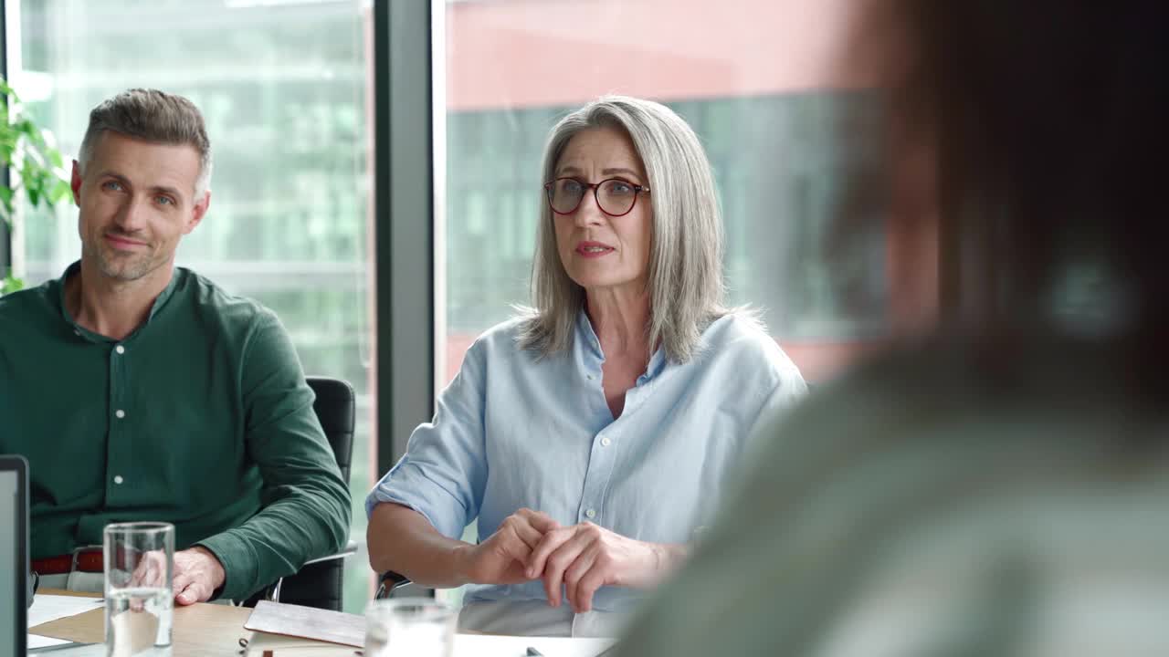 年长的女性导师在董事会会议室的高管团队会议上讲话。视频素材