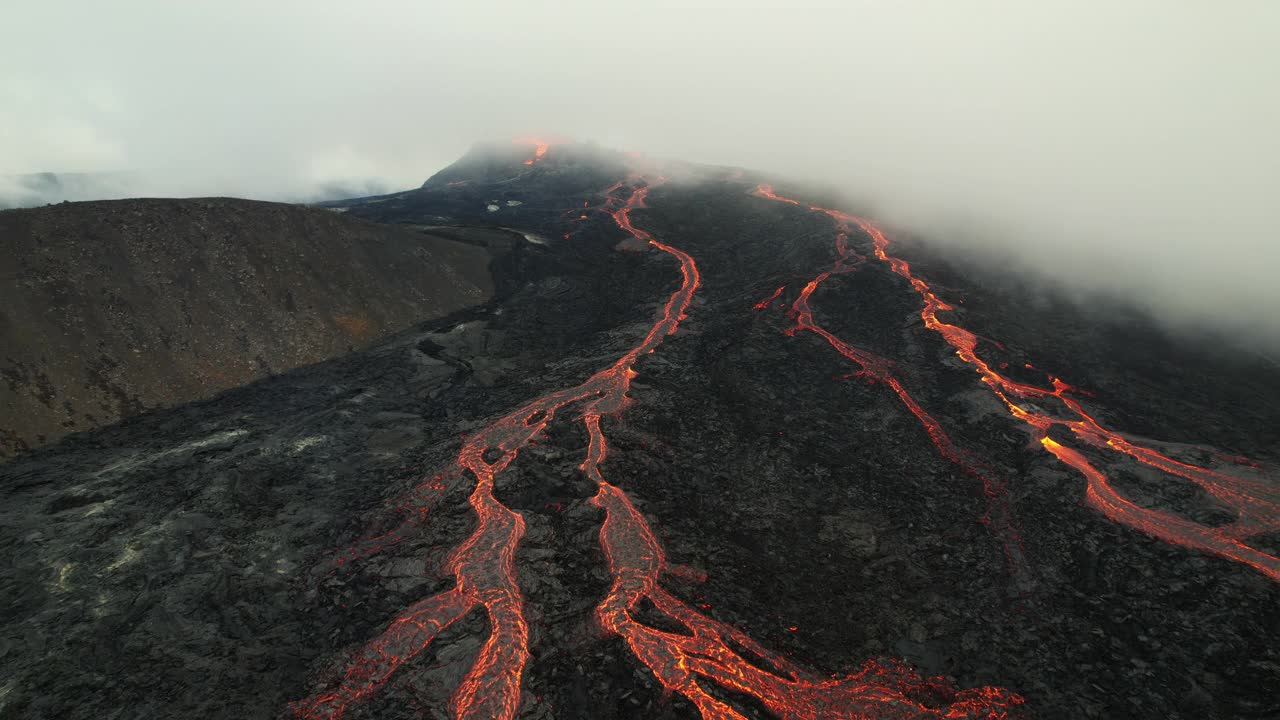 在冰岛雷克雅内半岛法格拉达斯火山，无人机向后飞行的照片显示了低空云层下的熔岩河视频素材