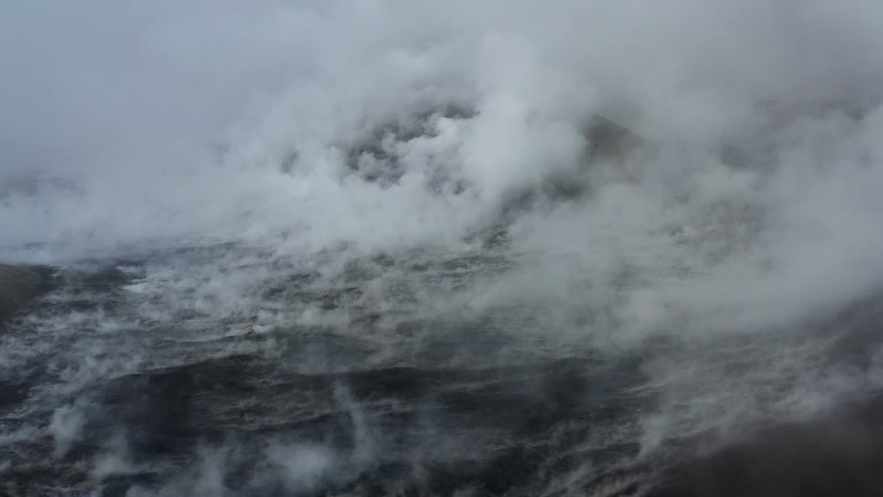 冰岛，雷克雅内半岛，fagradalsjall火山，一架无人机从冷却的熔岩场升起的烟雾中向后飞行视频素材