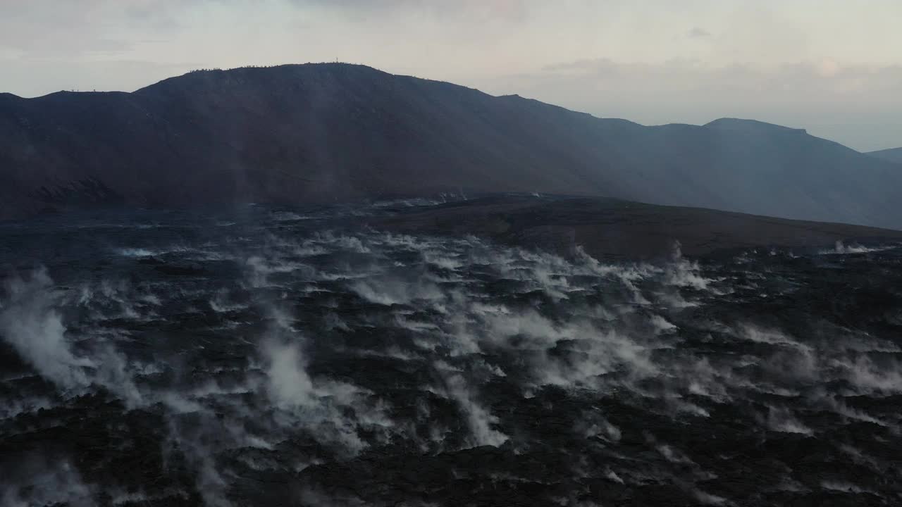 冰岛，雷克雅内半岛，法格拉达斯火山，无人机飞过冷却熔岩升起的烟雾视频素材