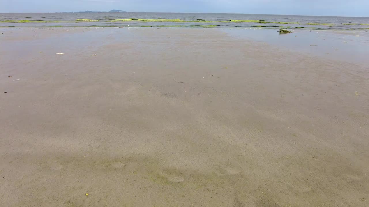 从左到右的镜头拍摄热带的泰国海滩，大海和沙子在多云的天空视频下载