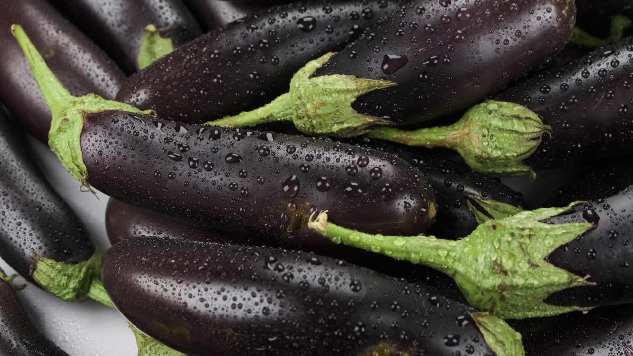 雨滴中成熟多汁的茄子全景图。蔬菜的背景。生水果和蔬菜视频素材