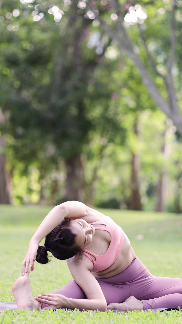 年轻的成年亚洲妇女在花园里自我练习瑜伽视频素材