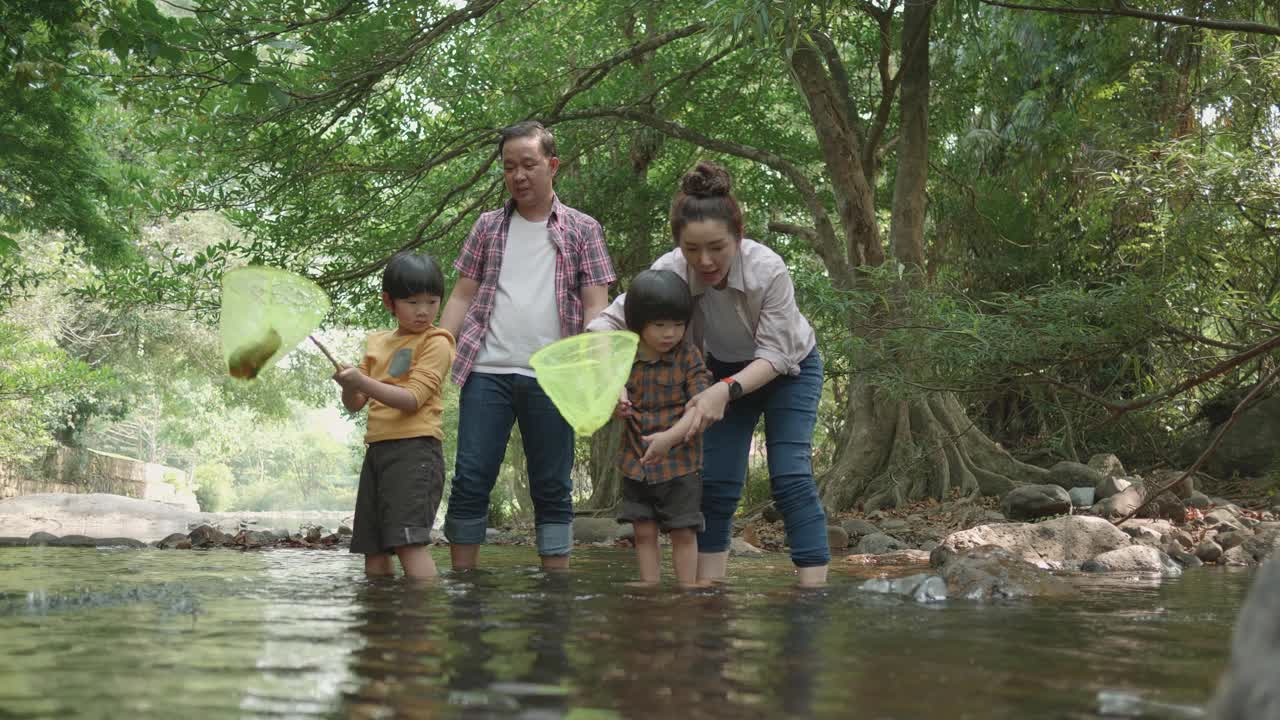 一家人训练儿子在河边钓鱼。视频素材