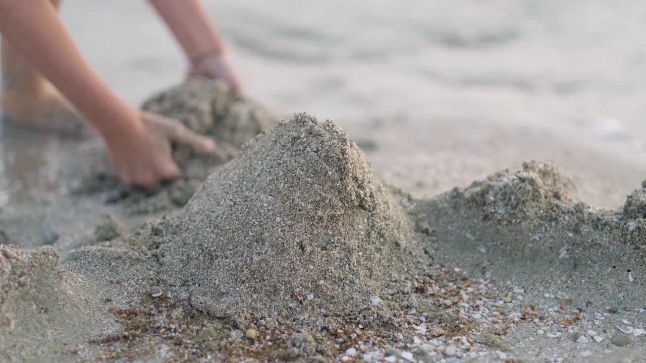 金发小男孩在沙滩上玩沙子，大海，大海。孩子建造沙堡房子。家庭暑假和去温暖的国家旅行视频素材