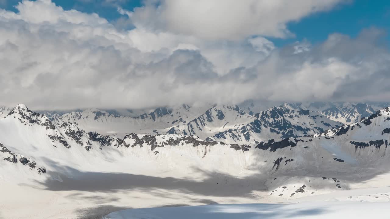 在美丽的雪峰和冰川上空的云朵中飞行。视频素材