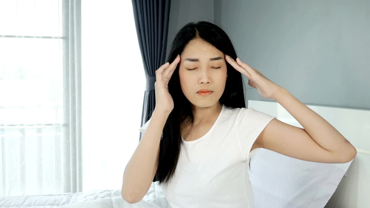 沮丧的美丽亚洲女人坐在她的床上视频素材