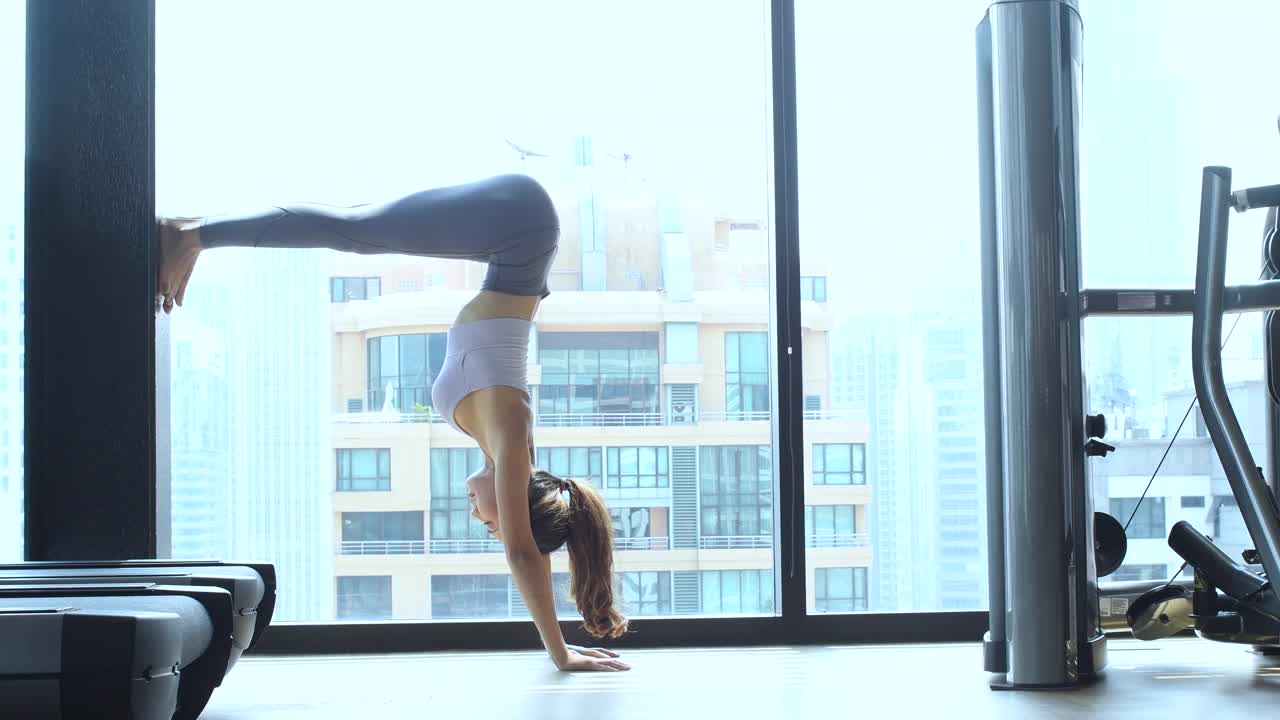 女子练习瑜伽手倒立姿势平衡力量和肩膀的柔韧性视频素材