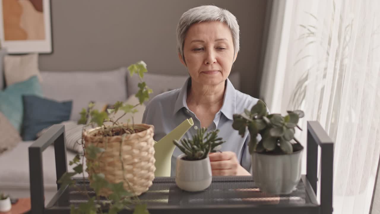 老妇人浇灌植物视频素材