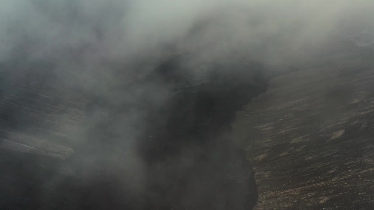 无人机在冰岛雷克雅内半岛fagradalsjall火山喷发形成的熔岩场上空的低空云层中飞行视频素材