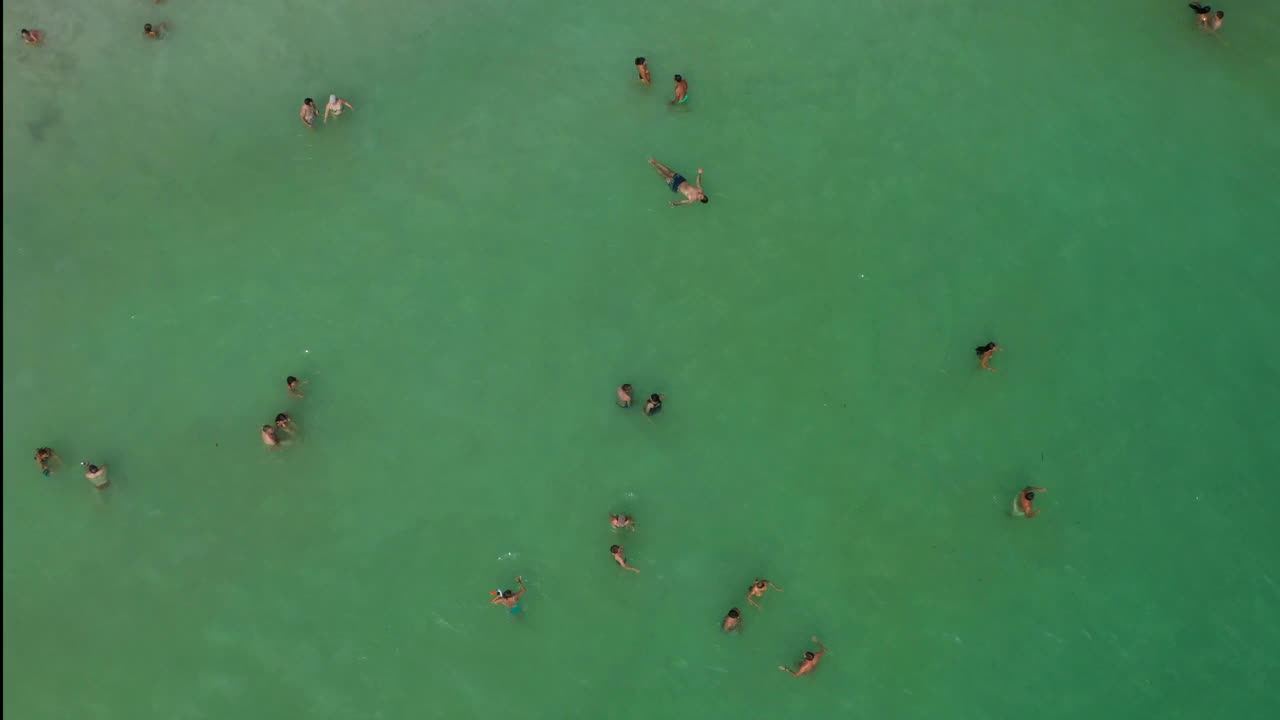 在Menorca，人们在水中用无人机观察大海视频素材