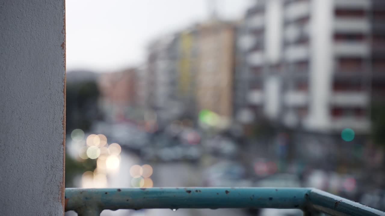 阴沉的雨天，模糊的城市风景散景，雨滴落在破旧生锈的住宅阳台上，雨滴浸湿和破坏混凝土。腐蚀的概念视频素材