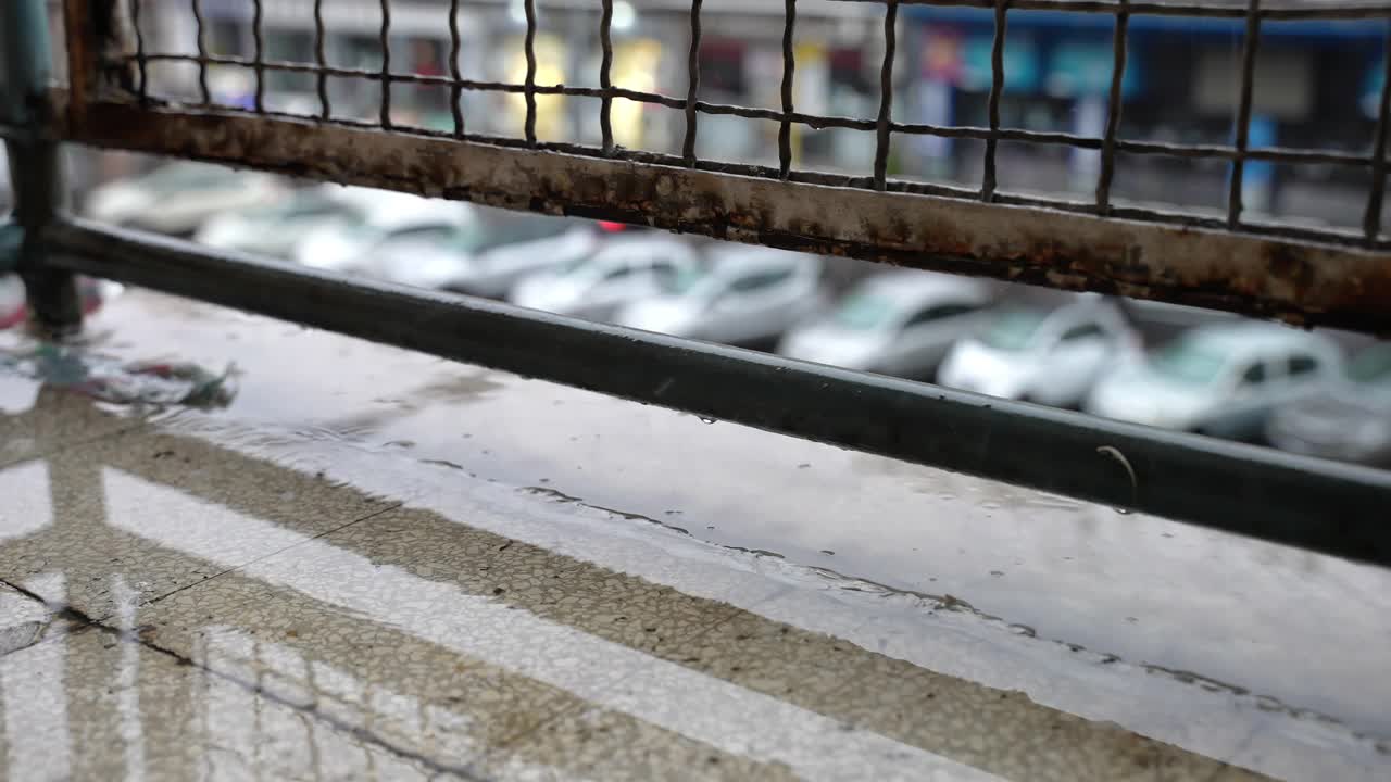 大雷雨后的腐蚀过程，持续的暴雨浸湿金属格栅表面，破坏建筑物的混凝土。水滴破坏物体的过程视频素材