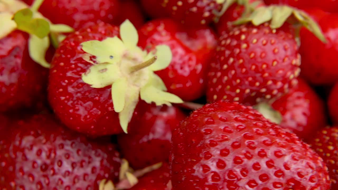 成熟的红色水果草莓旋转宏观极端近。季节性的夏季红浆果。慢慢旋转新鲜浆果堆。健康有机甜点，素食概念视频素材