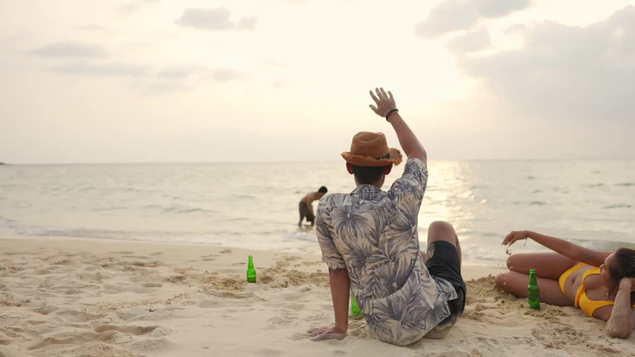 一群亚洲男人和女人朋友在夏天的假期在海滩上野餐视频素材