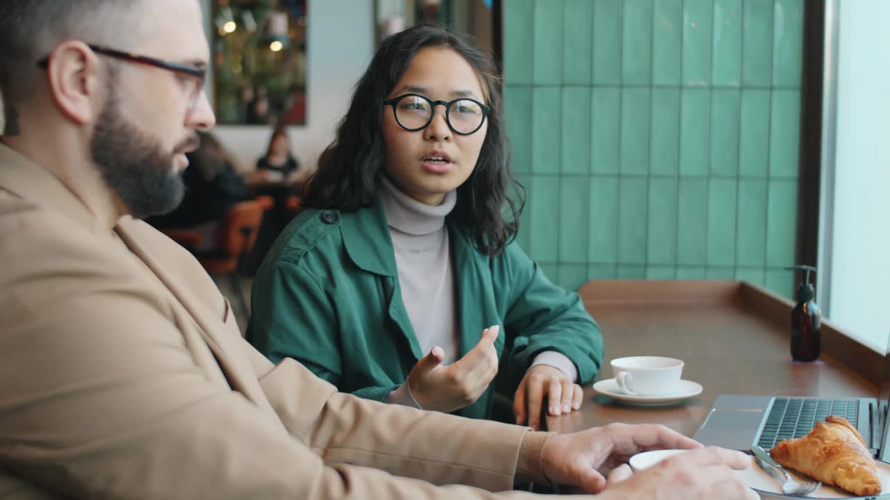 亚洲女商人与同事在咖啡馆喝茶视频素材