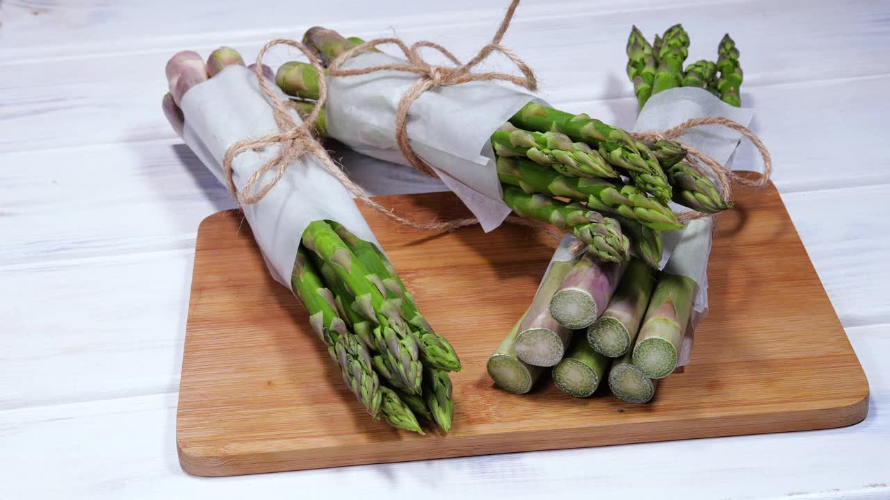 芦笋，新鲜生有机绿色芦笋芽特写，健康素食。生蔬菜、市场。素食的背景。慢动作4K超高清视频视频素材