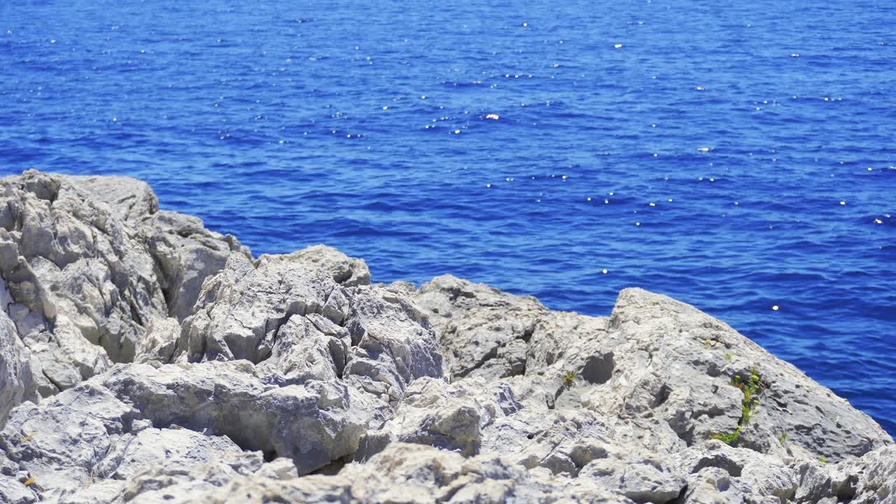 严酷的岩石海岸环境面前是深蓝色的大海视频素材