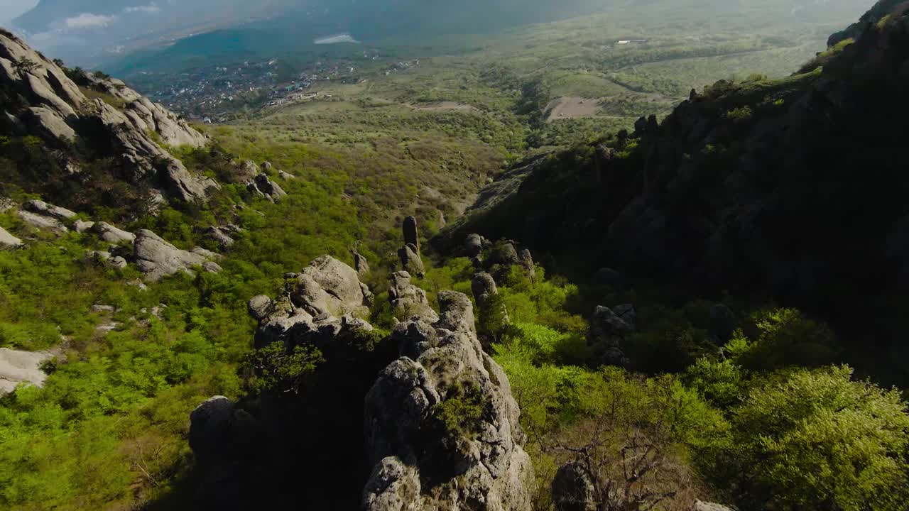 在山岩之间的极端飞行。射杀。在山坡上岩石形成的快速飞行。像飞行服一样在绿色山脉的岩石斜坡上飞行视频素材