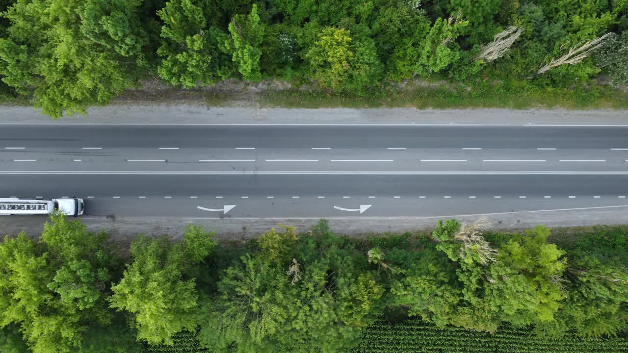 卡车、拖拉机和汽车，从柏油路上俯瞰树木。视频素材