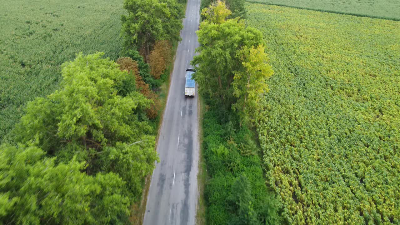 卡车在沥青乡村道路上的移动，车辆上的无人机飞过树木视频素材