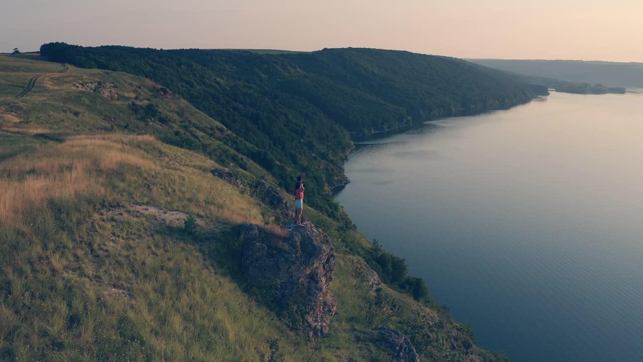 一男一女站在岩石嶙峋的山上，靠在河边视频素材