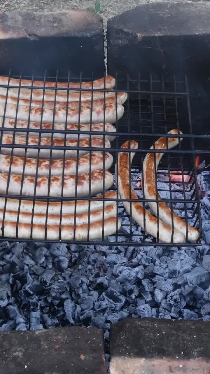 地面上有燃烧的煤炭和烤香肠的石制乡村炉子视频素材