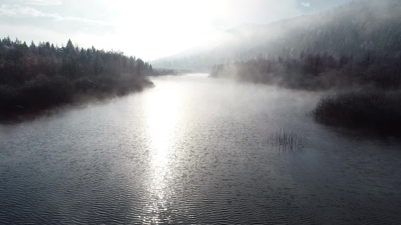 在冬天的早晨，穿越山河上的雾视频素材