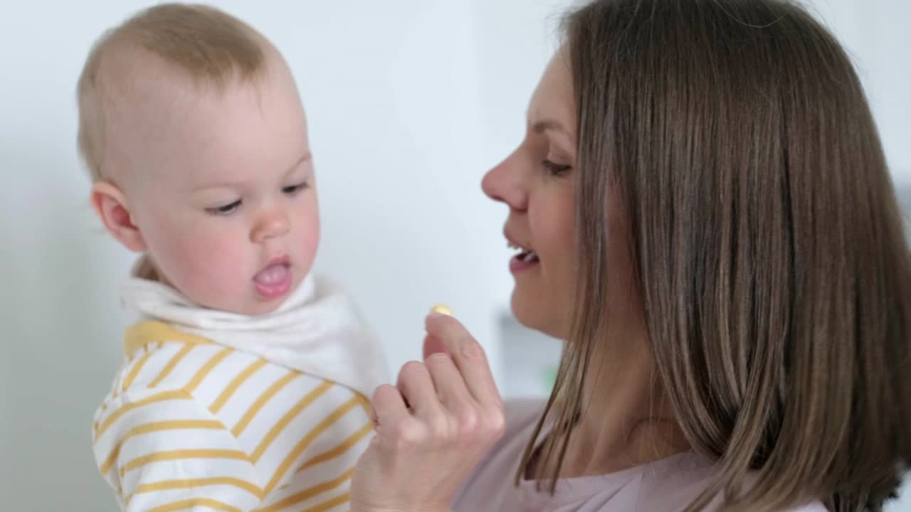 妈妈给孩子吃维他命。在家吃婴儿。健康食品，零食或午餐时间视频素材