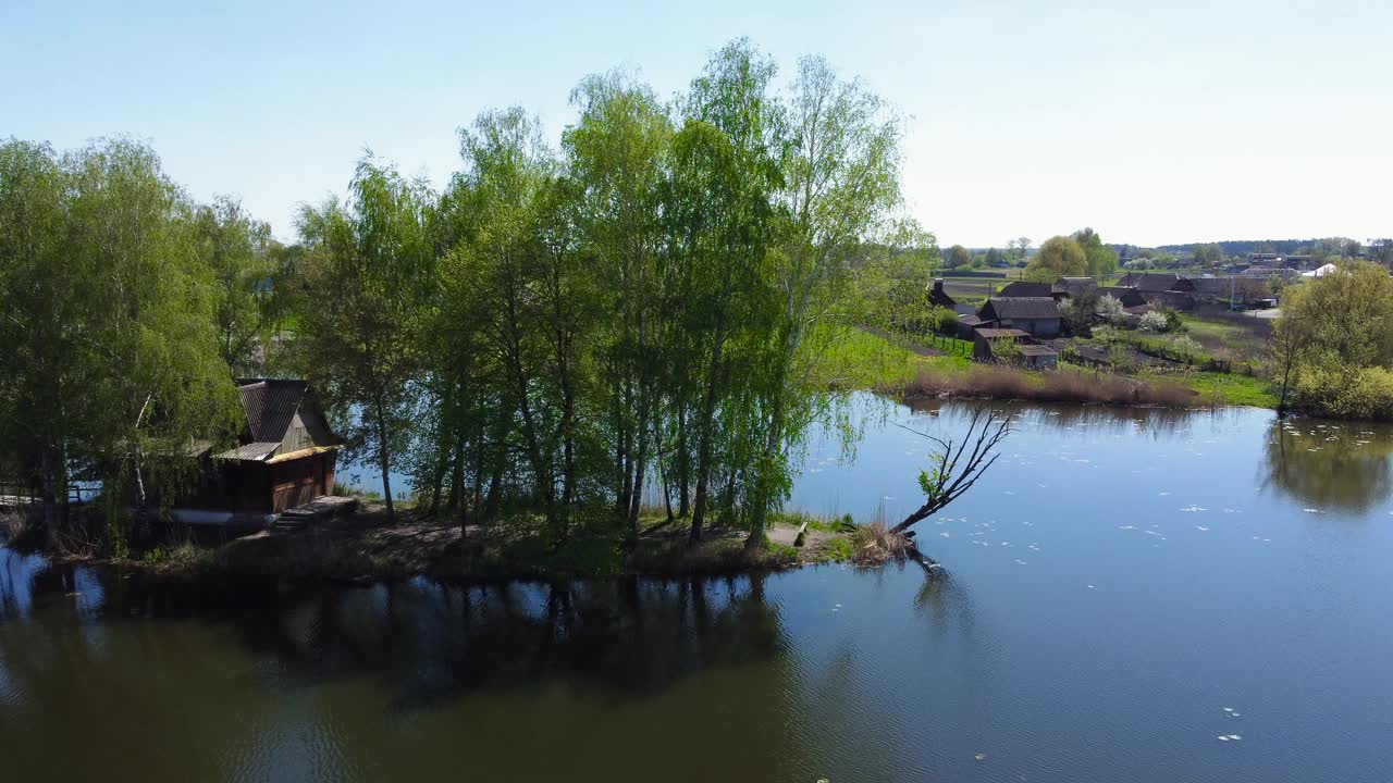 岛上的池塘与人行桥，小屋和树木在春天视频素材