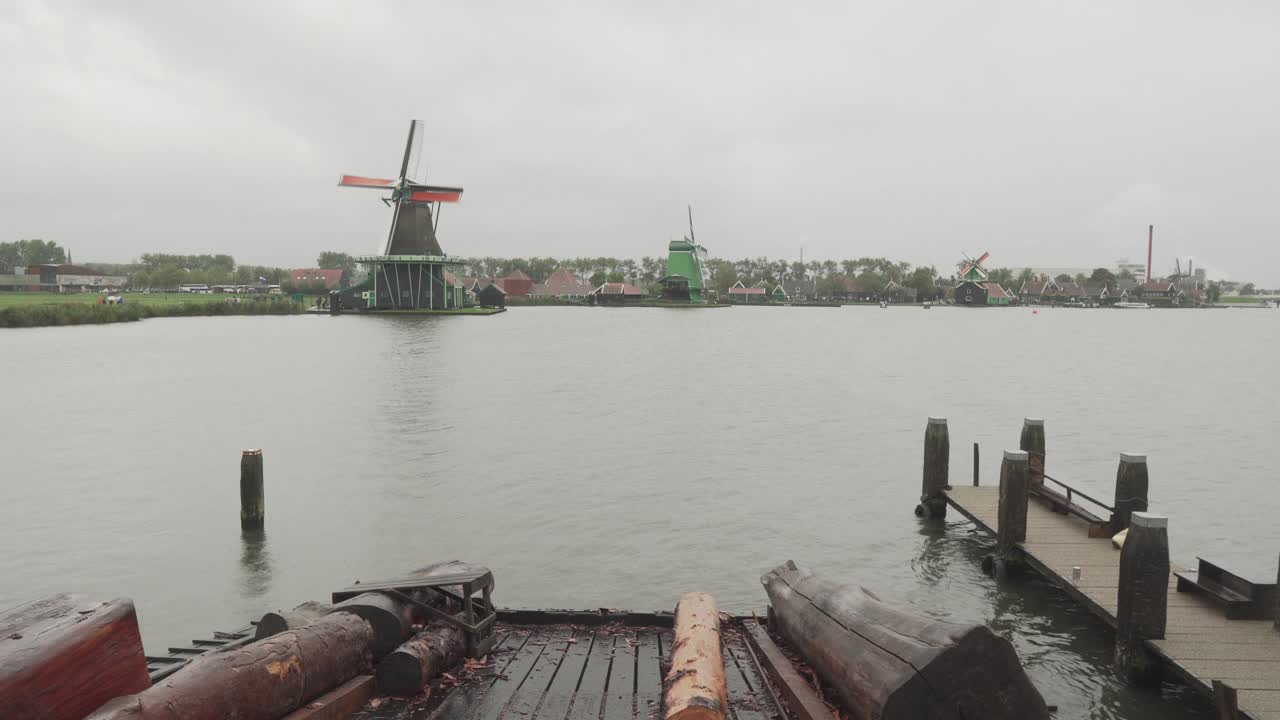 在荷兰Zaanse Schans, p . p .，码头上的树干，用于在恶劣天气下工作的当地风车的强力切割视频素材