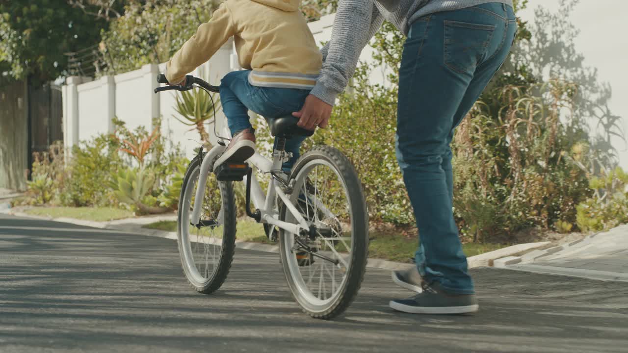 一个英俊成熟的男人教儿子在户外骑自行车的4k视频片段视频素材