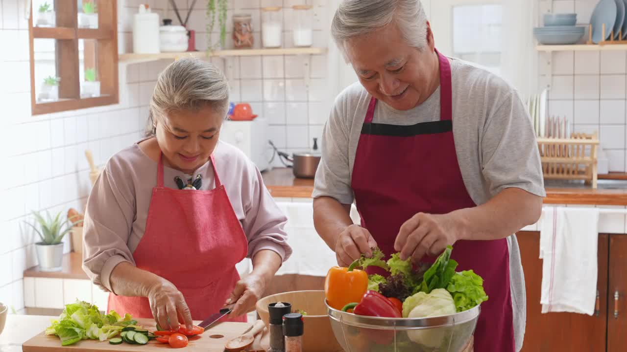 4K亚洲老夫妇一起在厨房做沙拉。视频素材