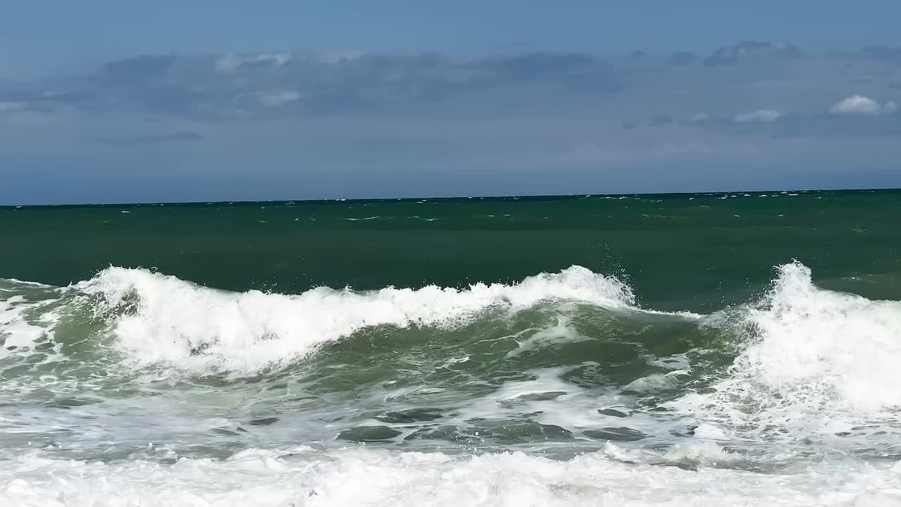 汹涌的海浪拍打着海岸线的缓慢运动视频素材