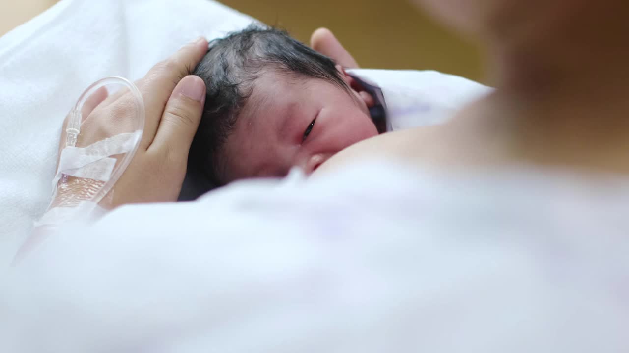 年轻漂亮的母亲，在医院给她刚出生的男婴喂奶视频素材