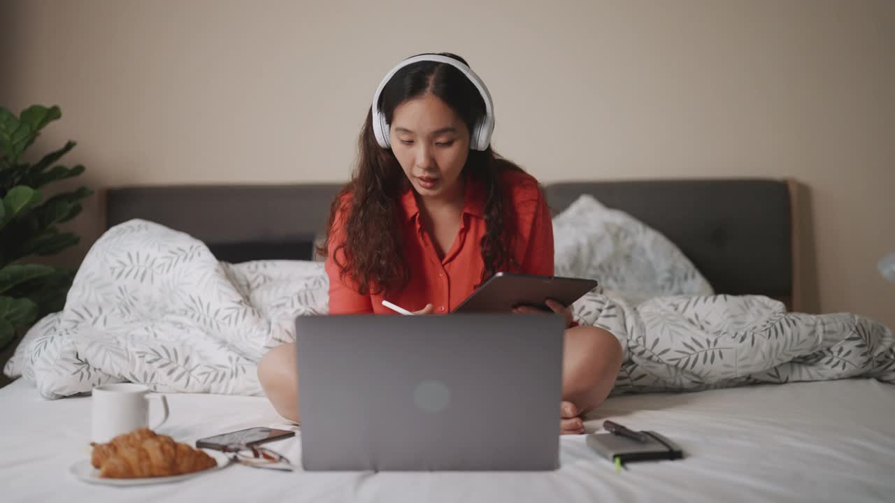 亚洲女人在卧室用笔记本电脑进行视频会议聊天视频素材