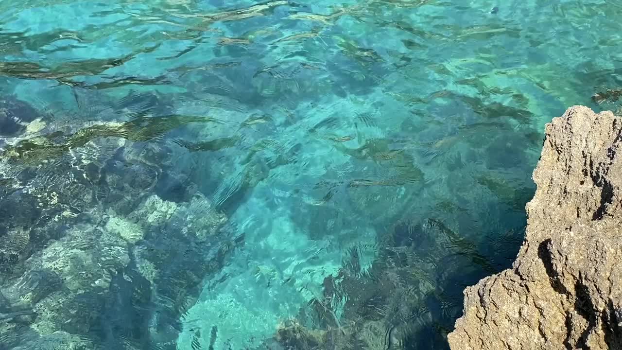 碧绿的海水，夏日美妙的海景。晶莹剔透、碧绿翠绿的海水背景。热带海浪。卵石滩。美妙的闪闪发光的水。放松，禅意，清新，夏日时光。视频素材