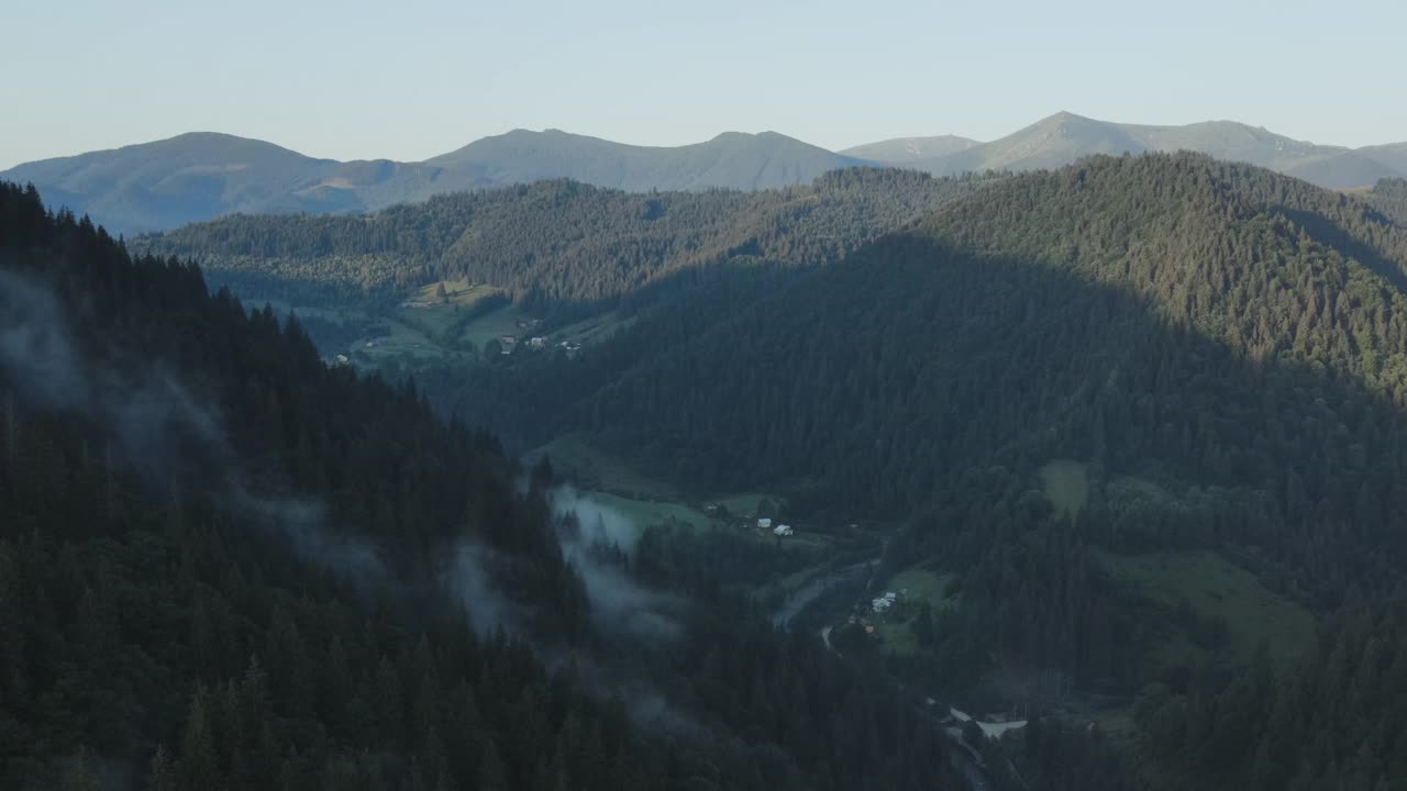 无人机拍摄的深度和野生森林在清晨薄雾高山和乡村在日出或日落。大自然的灵感。乡村地区有小房子，湍急的河流，碎石路视频素材