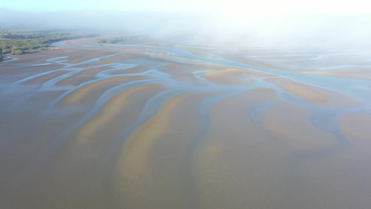 空中视角通过移动的云向下看沙质河岸和蓝色的水路。哈维湾昆士兰视频素材