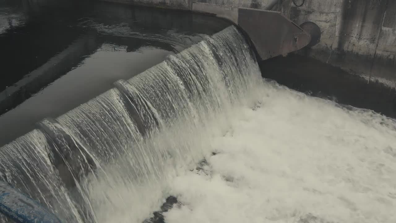 河水在河坝上淤积。水从水库中流出。视频素材