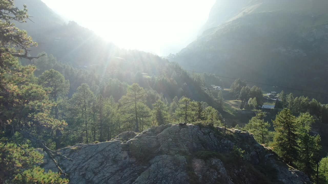 无人机拍摄的一名年轻女性徒步旅行者站在山上露出地表的岩石上视频素材