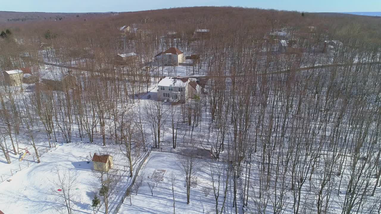 宾夕法尼亚州阿巴拉契亚州波科诺山区的一个农村社区。鸟瞰图在寒冷的阳光明媚的雪天。视频素材