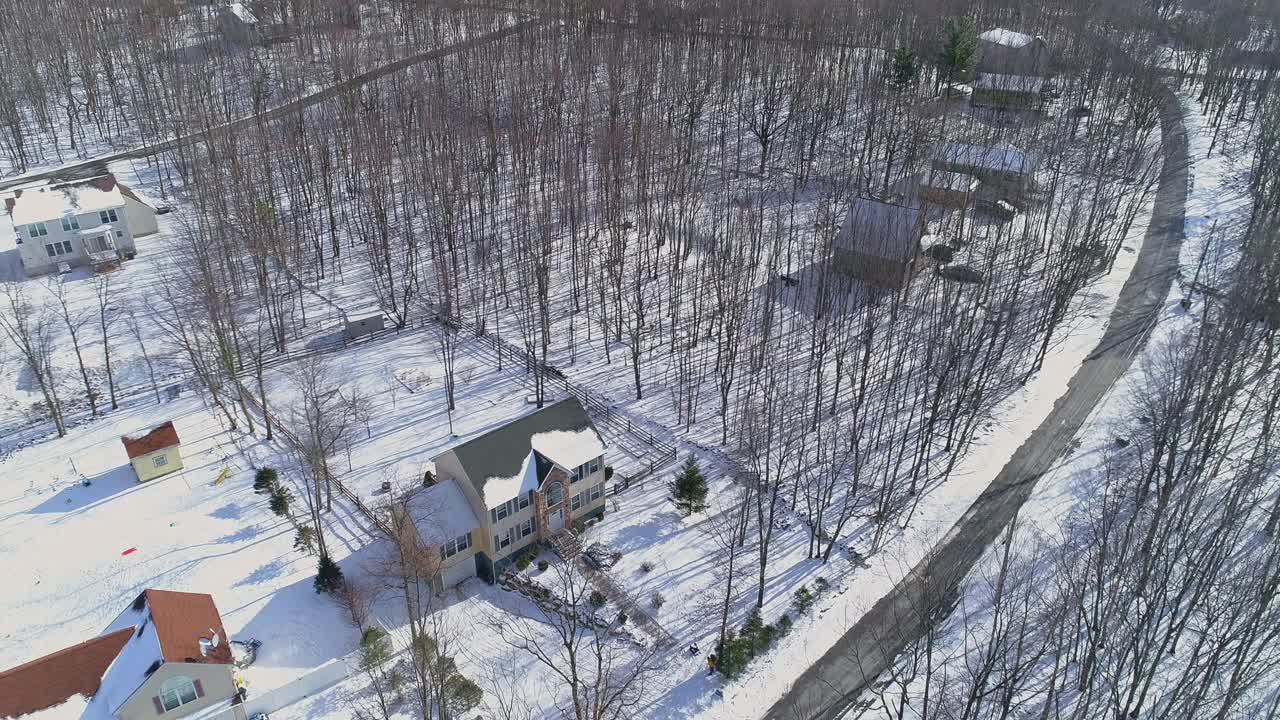 宾夕法尼亚州阿巴拉契亚州波科诺山区的一个农村社区。鸟瞰图在寒冷的阳光明媚的雪天。视频素材