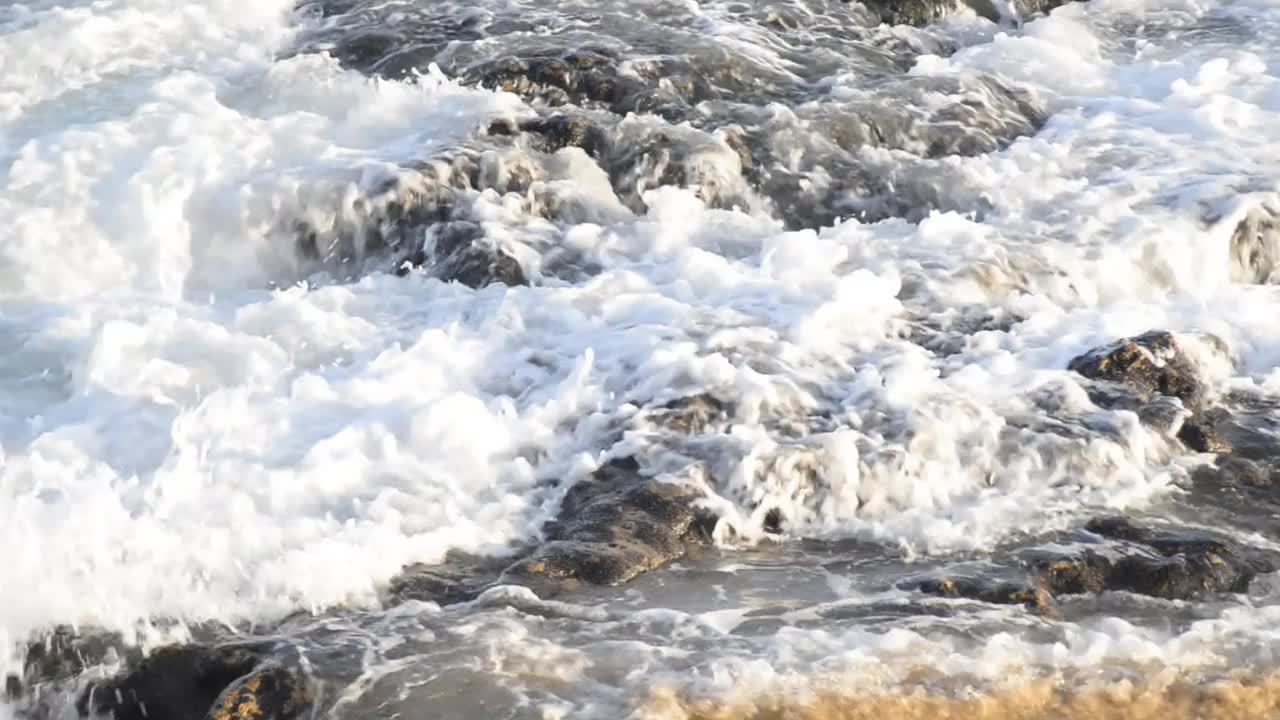 下午晚些时候，海浪拍打着里约热内卢Vermelho海滩的岩石。视频下载